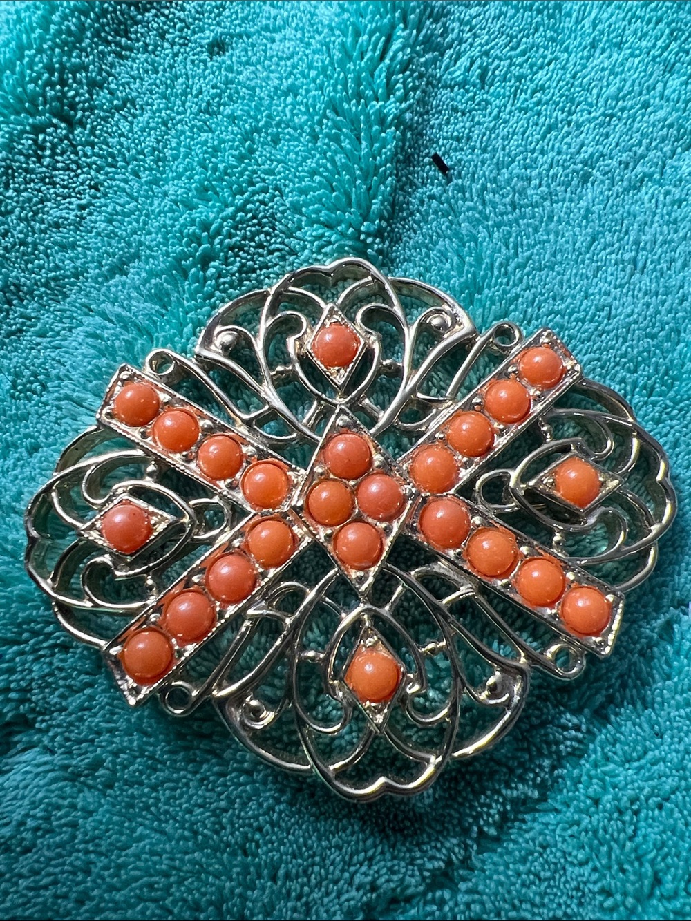 This vintage 1960s Sarah Coventry "Tangerine" brooch features coral-colored bead